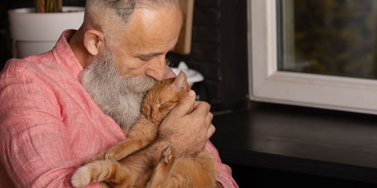 Un signore anziano bacia il suo gatto